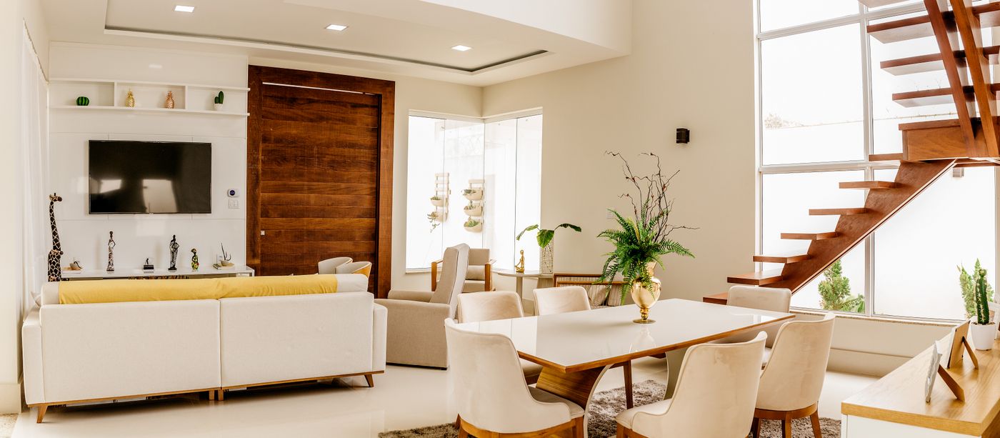 Intérieur lumineux avec cuisine ouverte, mobilier clair et escalier en bois